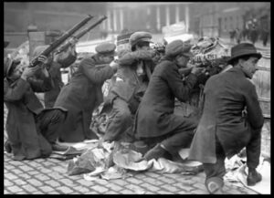 Irske oprørere på barrikaderne i påsken 1916, formentlig i Dublins gader (der var enkelte hændelser udenfor byen, men opstanden var i alt væsentligt en hovedstads-affære).