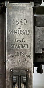 Fabrikationsmærkningen på de tyske MG08/15-maskingevær. "Spandau" er navnet på fabrikken, men blev hurtigt direkte associeret med selve våbnet.